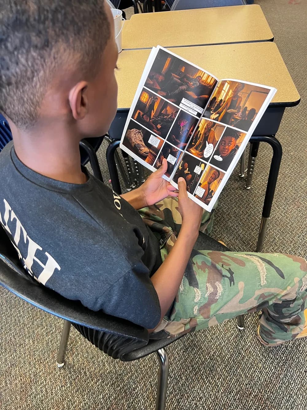 A young reader in class, deep into The Standard comic