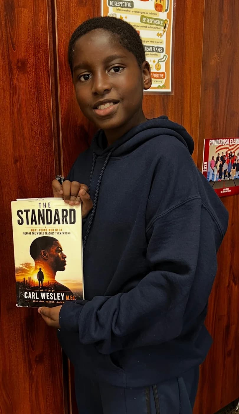 A young reader holding his copy of The Standard