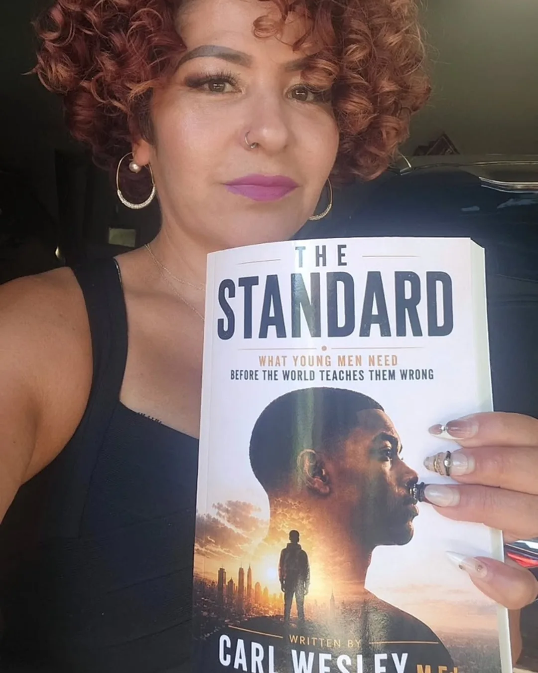 Reader holding The Standard by Carl Wesley