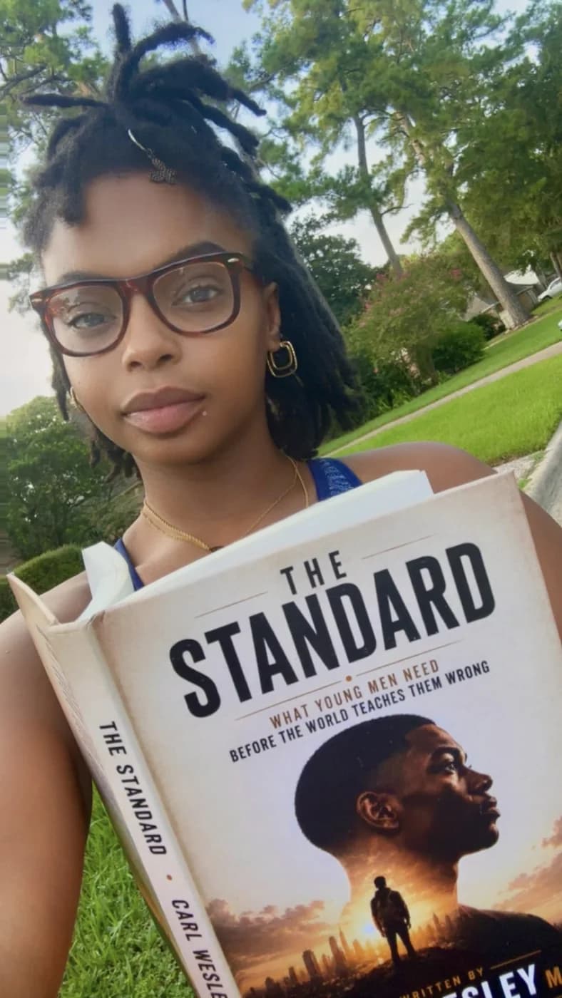Reader holding The Standard by Carl Wesley