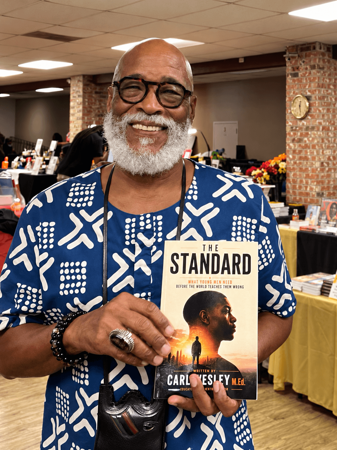 A reader in a blue shirt holding The Standard