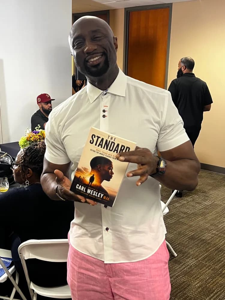 A supporter at a book event holding his copy of The Standard